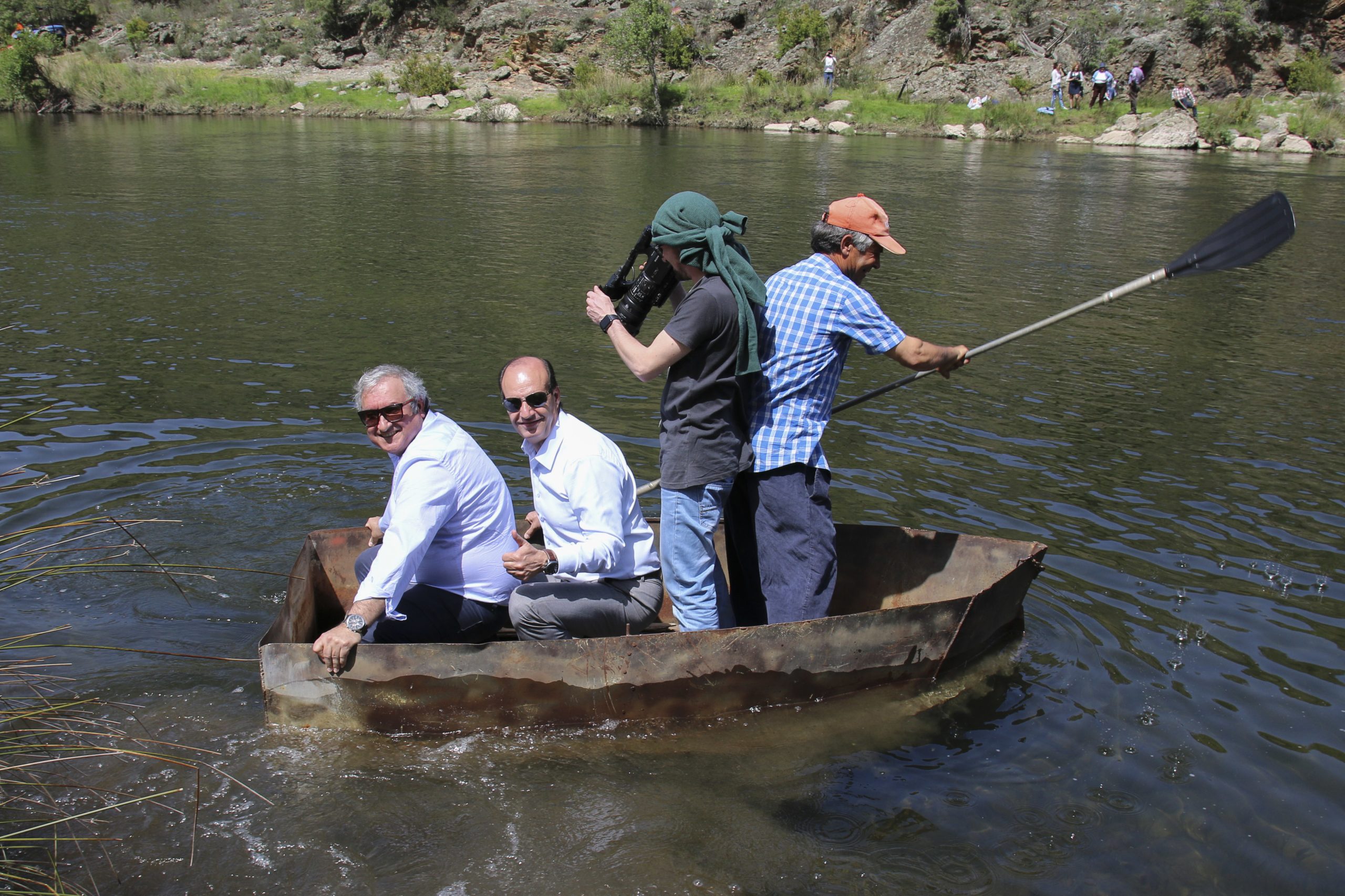 Dois presidentes numa barca pequena e enferrujada a remar por uma ponte
