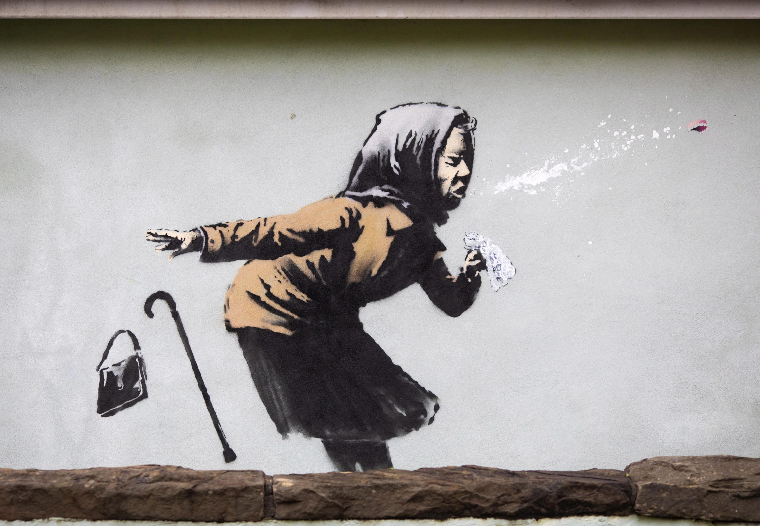 Adiada venda do edifício onde está mural de Banksy que mostra uma idosa a espirrar